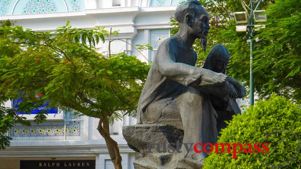 Ho Chi Minh watches over the downtown square, flanked by global brands.